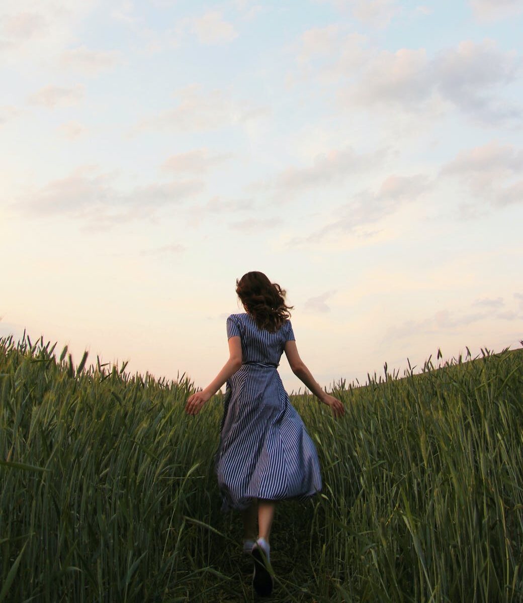 woman in blue dress standing on green grass field