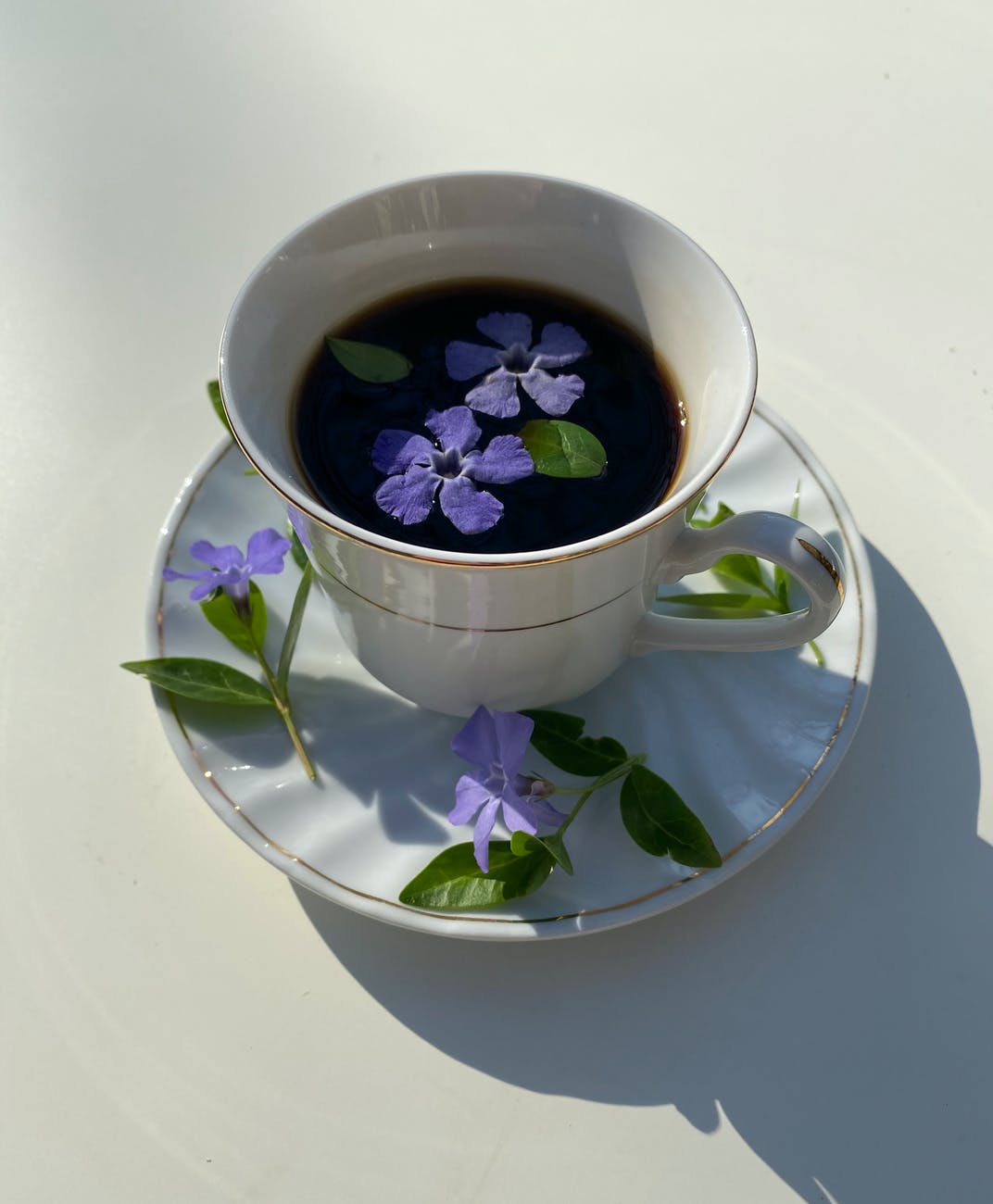 cup of coffee decorated with flowers with leaves on saucer