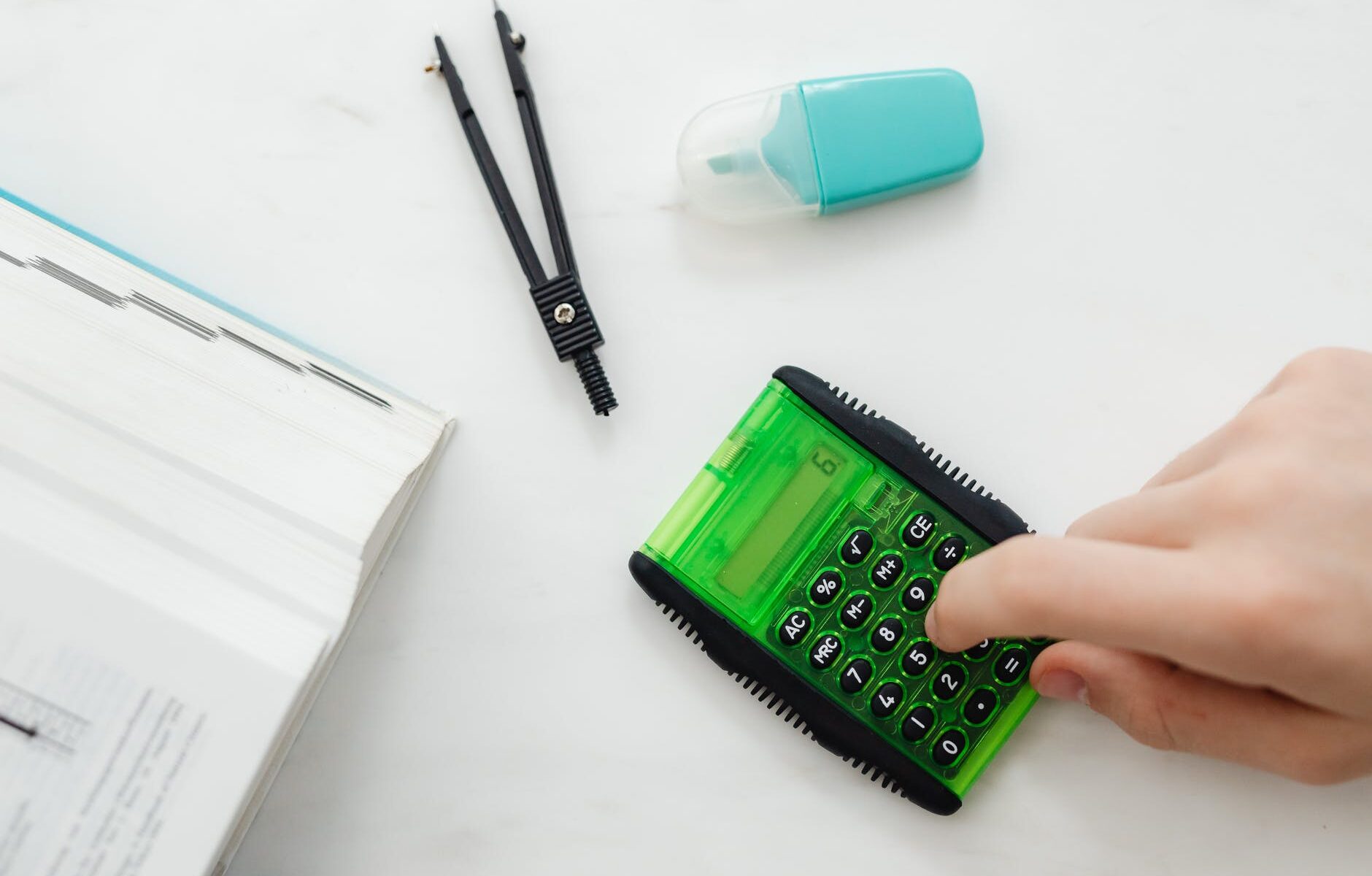 person using a small green and black calculator