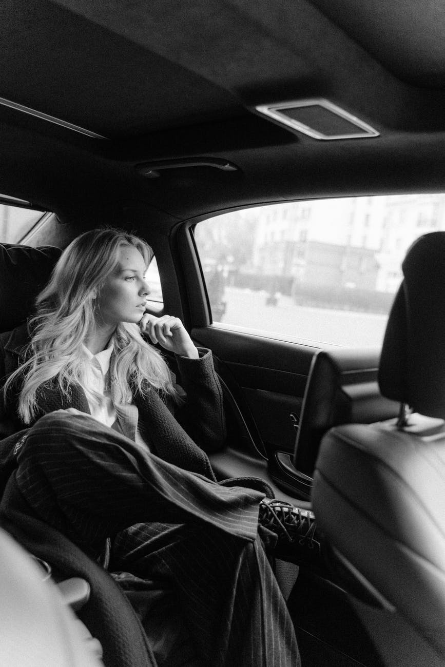 grayscale photo of woman inside a car