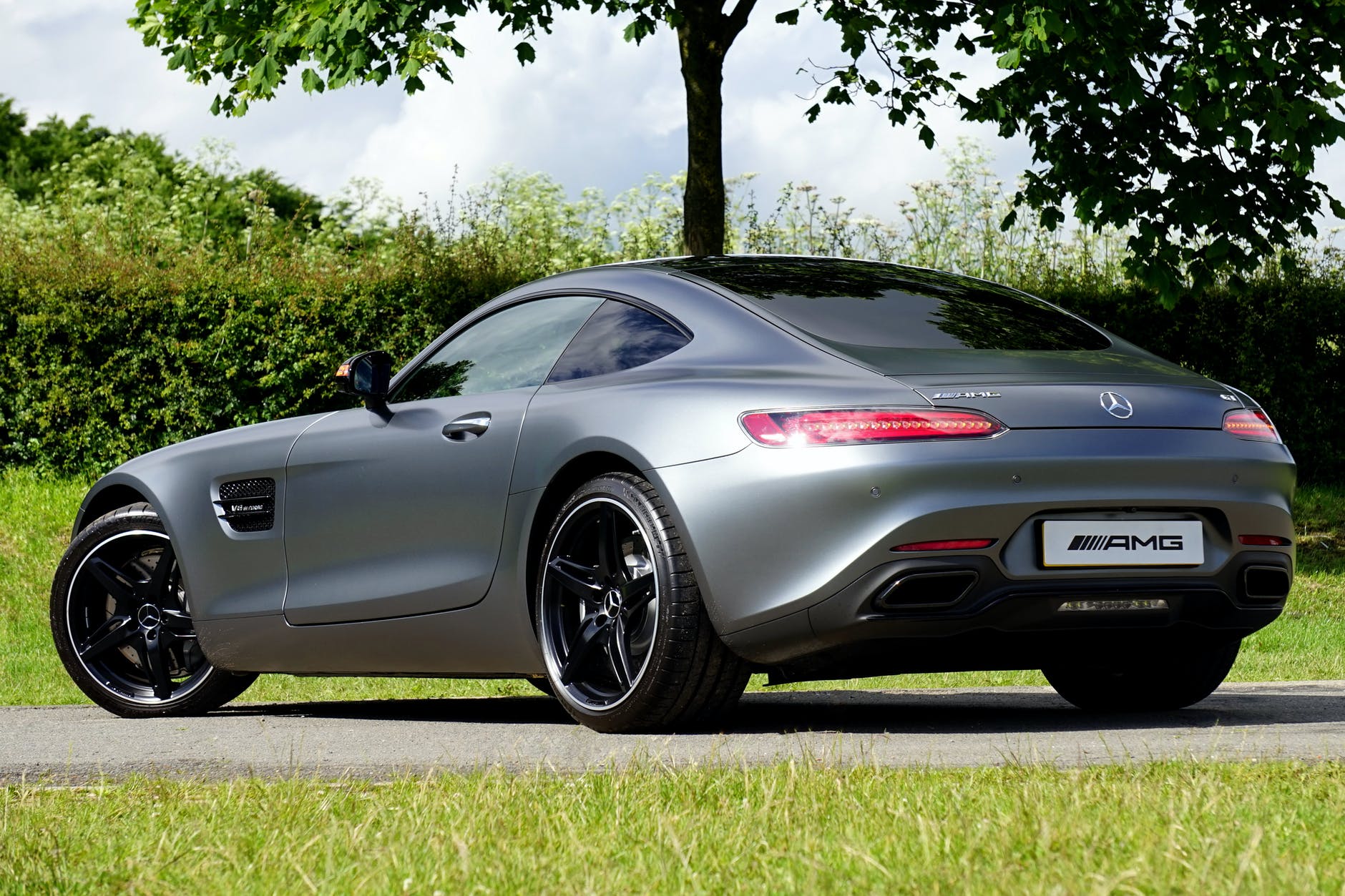 gray mercedes benz amg coupe parked near tree