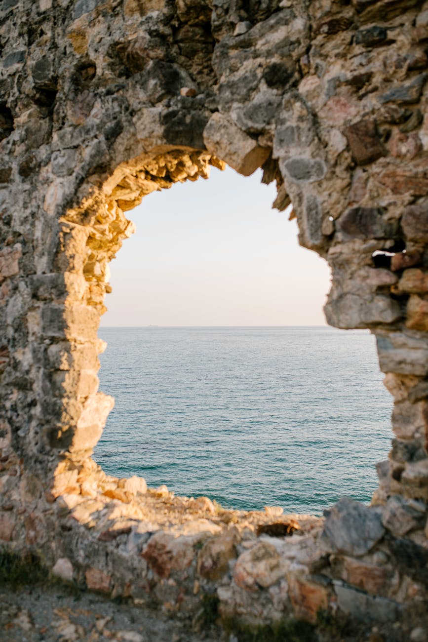 natural window in rocky cave and blue ocean