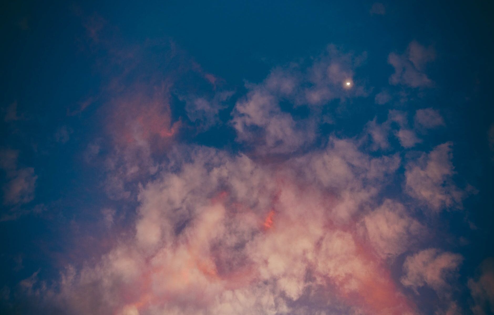 tiny star and pink clouds in evening sky
