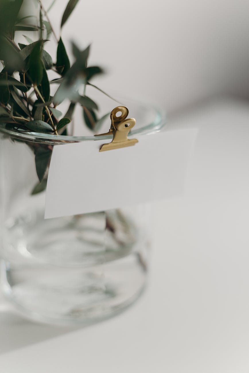 gold wedding band on clear glass vase